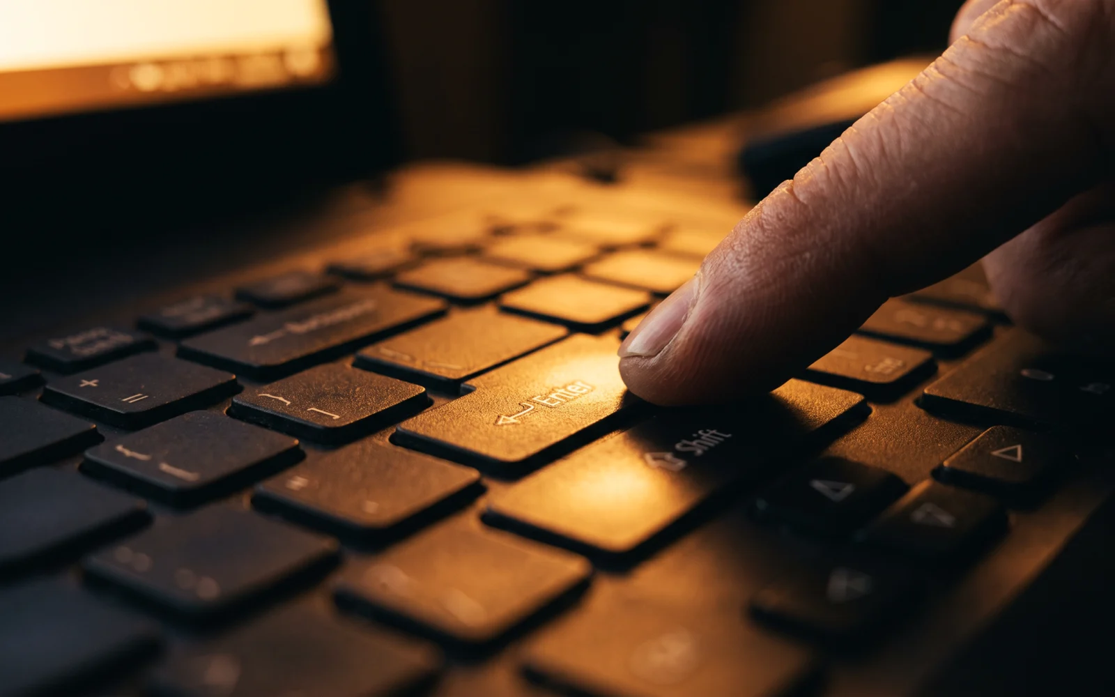 Hands entering information on a laptop, in a navy duotone.